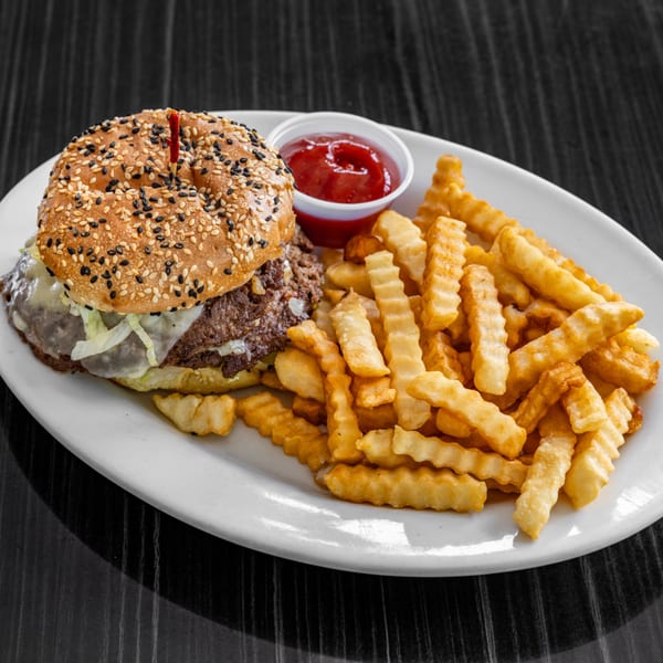Victoria's Diner cheeseburger with melted cheese, shredded lettuce, and crinkle-cut fries with ketchup.